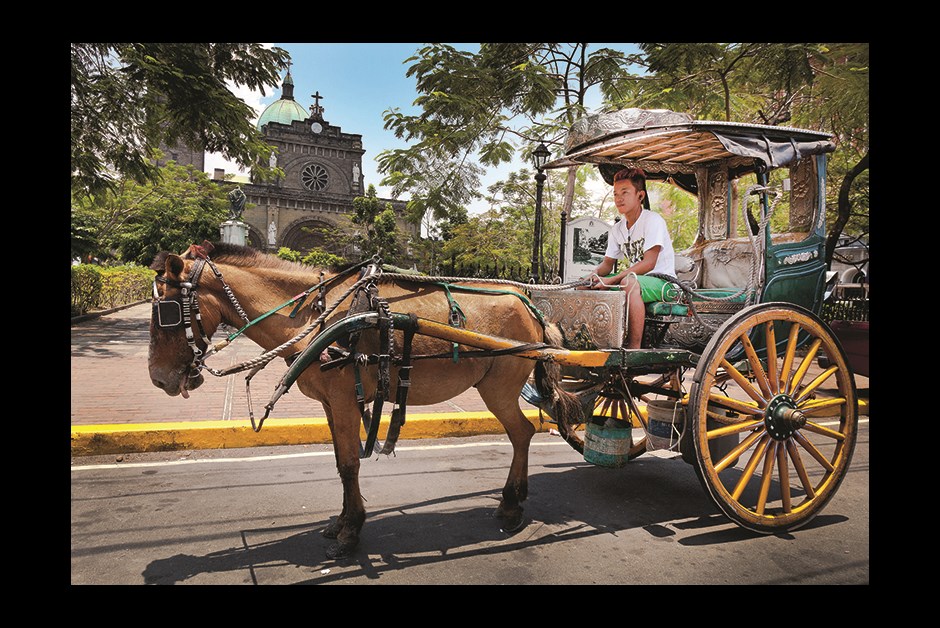 HORSE-DRAWN CARRIAGES OUTSIDE MANILA CATHEDRAL OFFER TOURS OF INTRAMUROS